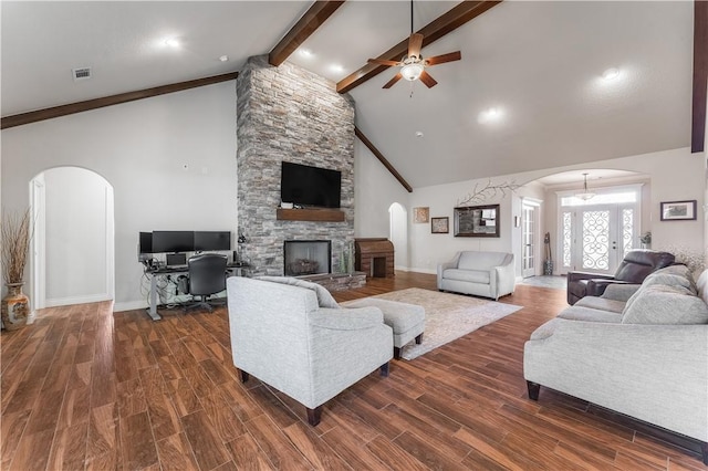 living area featuring arched walkways, a fireplace, and dark wood finished floors