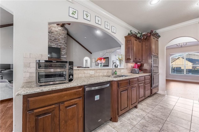 kitchen with ornamental molding, appliances with stainless steel finishes, backsplash, and a sink