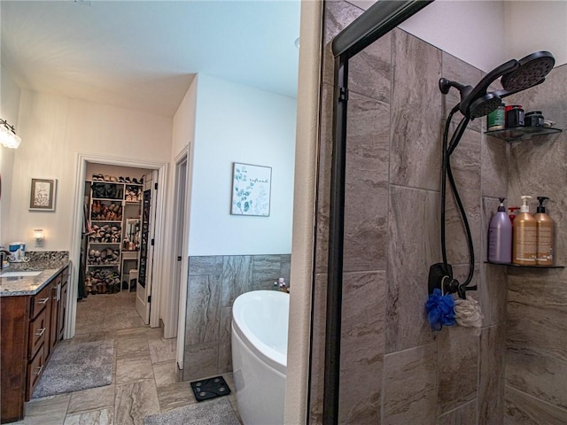 bathroom featuring vanity, tile walls, and plus walk in shower