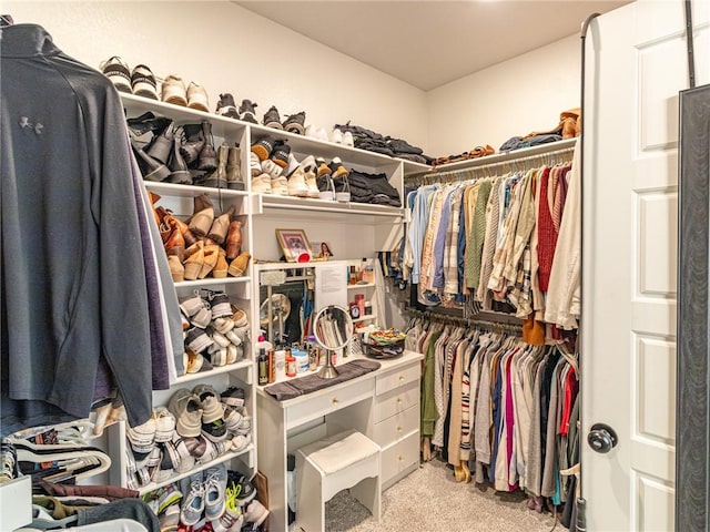 walk in closet featuring light colored carpet