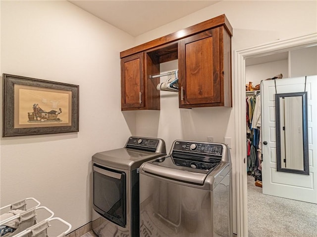 washroom with cabinets, washing machine and dryer, and light colored carpet