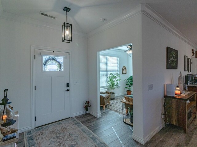 foyer with hardwood / wood-style floors, ceiling fan, and crown molding