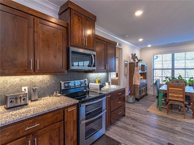 kitchen with stainless steel appliances, light stone counters, dark hardwood / wood-style flooring, backsplash, and crown molding