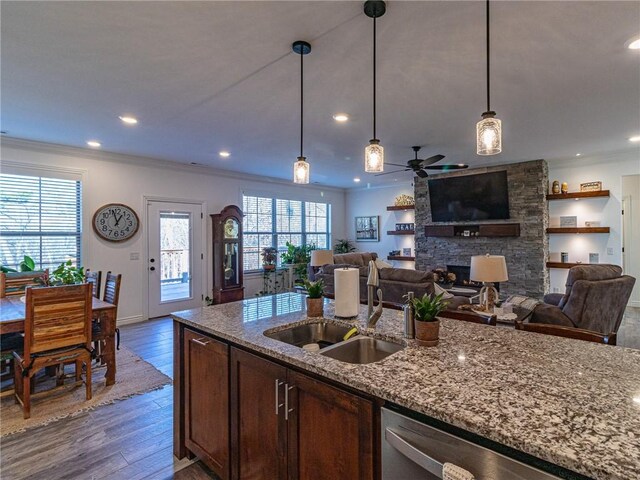 kitchen with light stone countertops, stainless steel dishwasher, ceiling fan, and sink