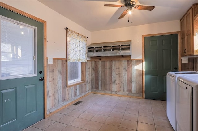 laundry area with ceiling fan, cabinets, independent washer and dryer, wooden walls, and light tile patterned floors