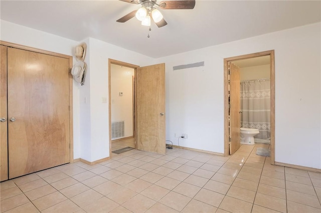 unfurnished bedroom featuring ceiling fan, light tile patterned floors, connected bathroom, and a closet