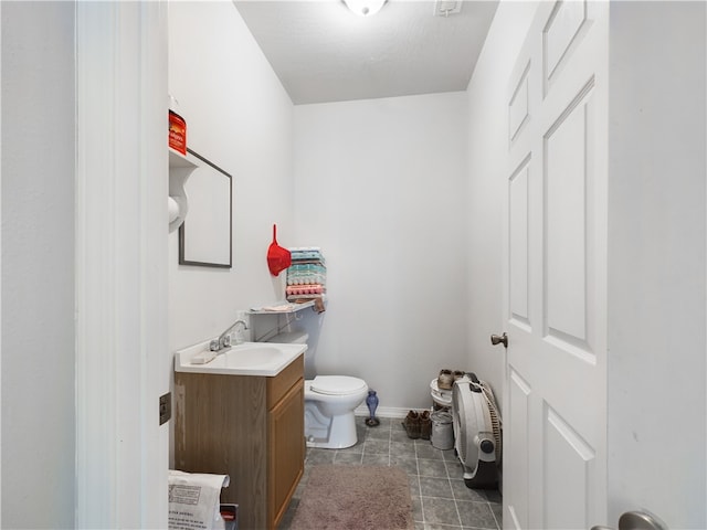 bathroom featuring vanity, tile patterned floors, toilet, and baseboards