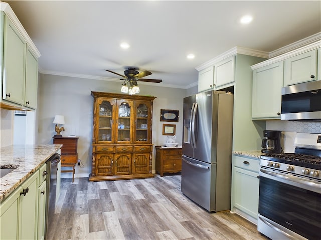 kitchen featuring a ceiling fan, light wood finished floors, appliances with stainless steel finishes, green cabinets, and crown molding