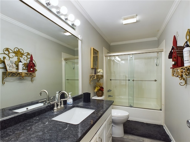 bathroom with toilet, vanity, crown molding, and bath / shower combo with glass door