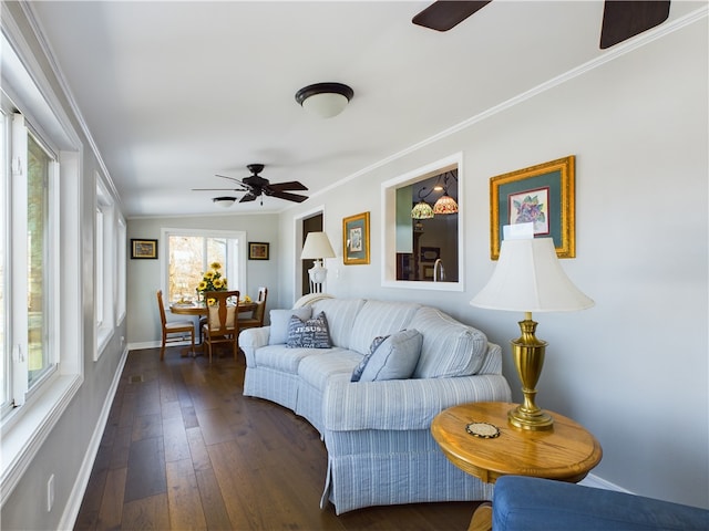 living room featuring baseboards, dark wood-style floors, a ceiling fan, and crown molding