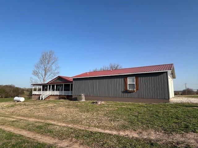 exterior space featuring metal roof and a front lawn