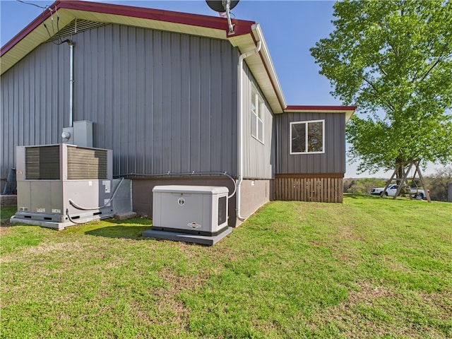 view of property exterior featuring an outbuilding, central AC unit, a lawn, and a pole building