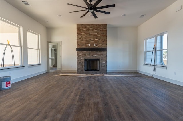 unfurnished living room featuring a healthy amount of sunlight and dark wood-type flooring