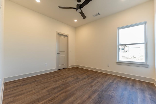 empty room with ceiling fan and dark hardwood / wood-style flooring