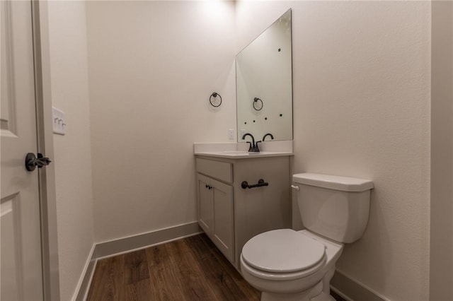 bathroom with hardwood / wood-style floors, vanity, and toilet