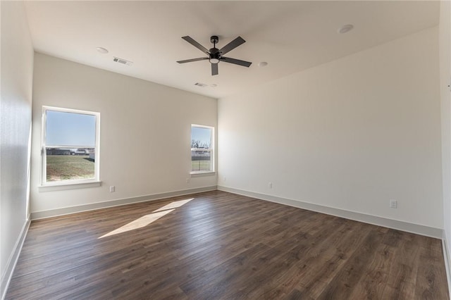 13121 Bethel Blacktop Rd, Farmington, AR 72730 - unfurnished room with visible vents, dark wood-type flooring, a healthy amount of sunlight, and ceiling fan