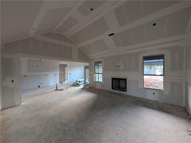 unfurnished living room featuring a fireplace, vaulted ceiling, and a healthy amount of sunlight