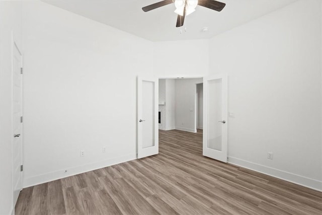 unfurnished bedroom with ceiling fan, baseboards, and wood finished floors