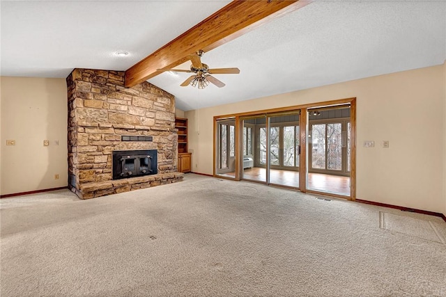 unfurnished living room with ceiling fan, lofted ceiling with beams, a textured ceiling, light carpet, and a stone fireplace