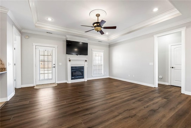 unfurnished living room featuring a healthy amount of sunlight, a raised ceiling, ceiling fan, and crown molding