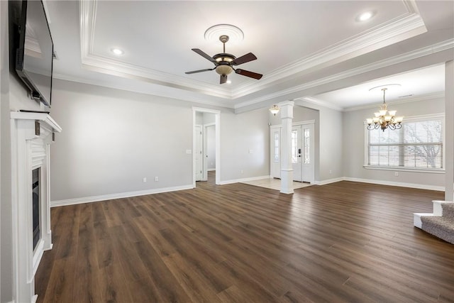 unfurnished living room featuring ceiling fan with notable chandelier, a raised ceiling, and crown molding