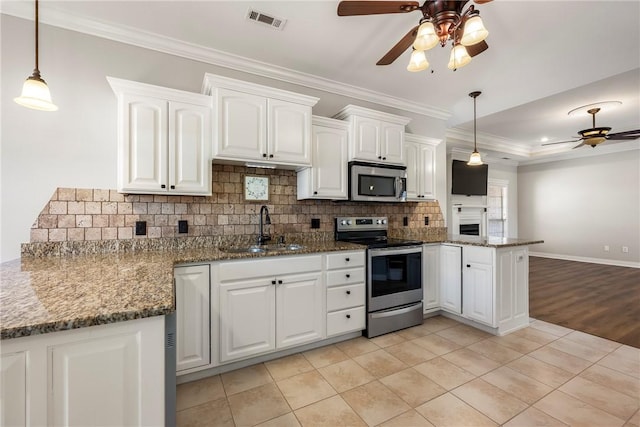 kitchen with white cabinets, decorative light fixtures, sink, and stainless steel appliances