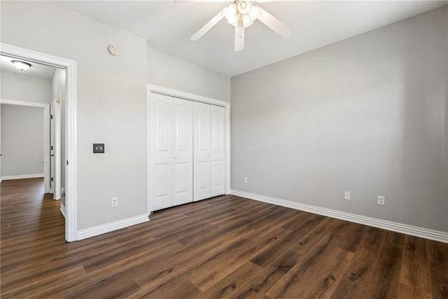 unfurnished bedroom with ceiling fan, a closet, and dark hardwood / wood-style floors