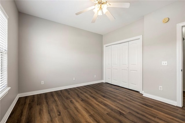 unfurnished bedroom featuring ceiling fan, dark wood-type flooring, and a closet