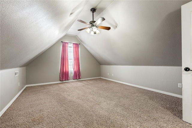 additional living space featuring carpet flooring, ceiling fan, lofted ceiling, and a textured ceiling