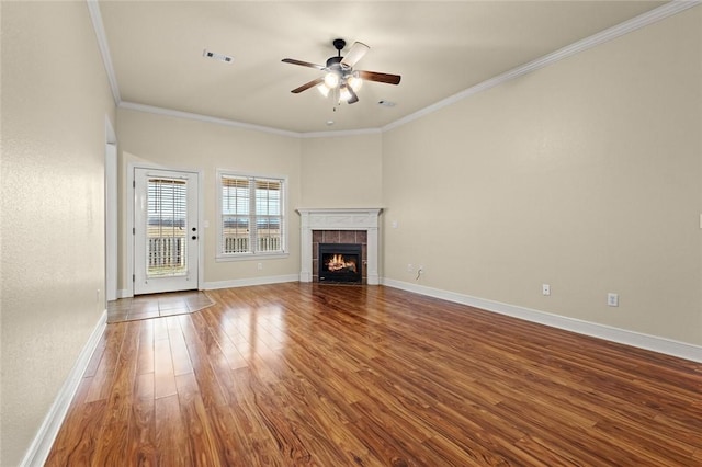 unfurnished living room featuring a tile fireplace, hardwood / wood-style flooring, ceiling fan, and crown molding