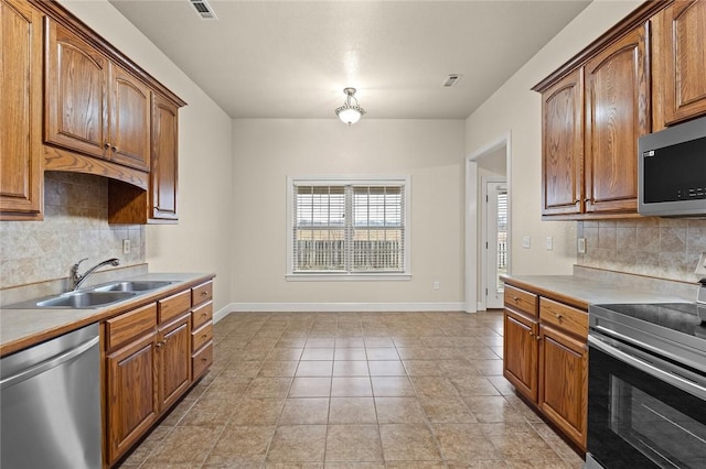 kitchen with tasteful backsplash, sink, light tile patterned floors, and stainless steel appliances