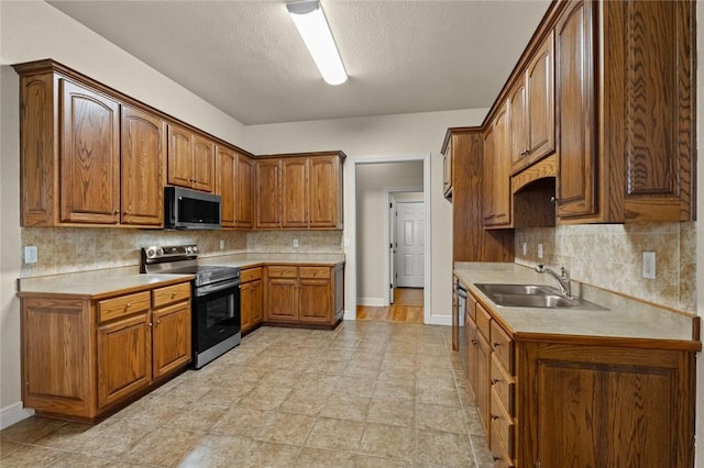 kitchen with tasteful backsplash, sink, a textured ceiling, and appliances with stainless steel finishes