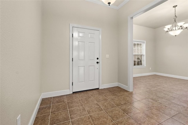 foyer entrance with tile patterned floors, a notable chandelier, and ornamental molding