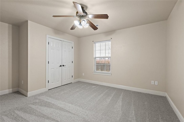 unfurnished bedroom featuring a closet, ceiling fan, and light colored carpet