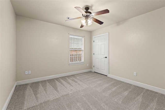 carpeted spare room featuring ceiling fan