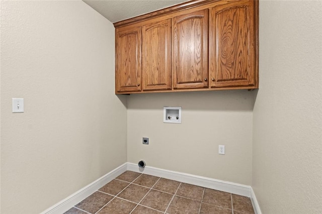 clothes washing area with cabinets, hookup for a washing machine, dark tile patterned floors, and electric dryer hookup