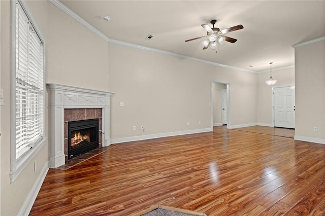 unfurnished living room featuring a fireplace, hardwood / wood-style floors, ceiling fan, and ornamental molding