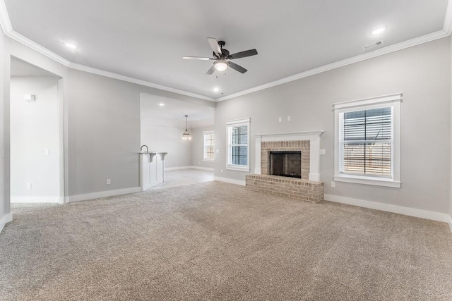 unfurnished living room featuring ceiling fan, light colored carpet, ornamental molding, and a brick fireplace