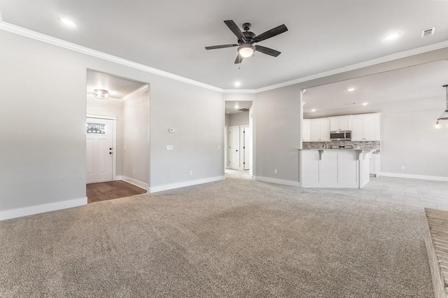 unfurnished living room featuring ceiling fan, crown molding, and light carpet