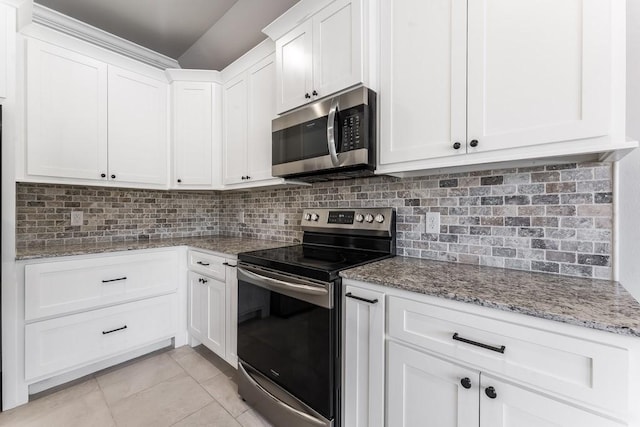 kitchen with light stone counters, stainless steel appliances, light tile patterned floors, tasteful backsplash, and white cabinets