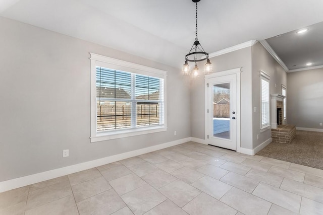 unfurnished dining area featuring a fireplace, light tile patterned floors, crown molding, and an inviting chandelier