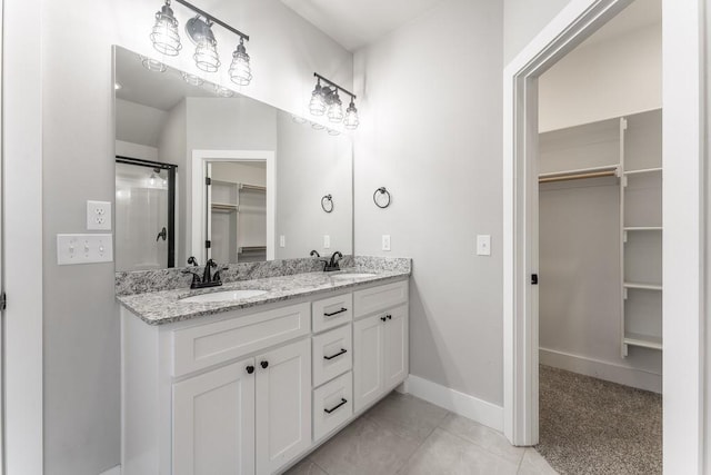 bathroom with tile patterned flooring, a shower, and vanity