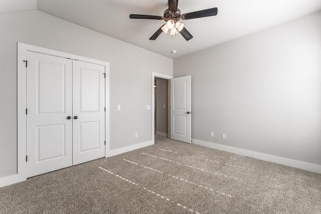 unfurnished bedroom featuring ceiling fan, a closet, lofted ceiling, and carpet flooring