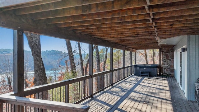 deck with a mountain view and a hot tub