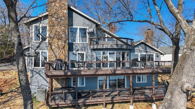 back of property featuring a balcony and a deck