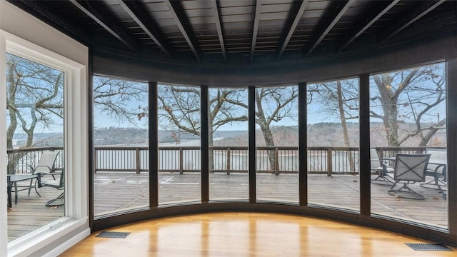 unfurnished sunroom featuring a water view