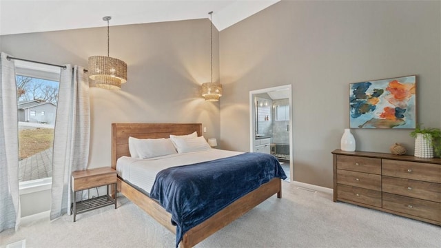 bedroom with a chandelier, light colored carpet, high vaulted ceiling, and ensuite bath