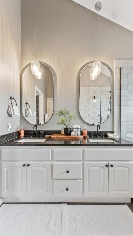 bathroom with vanity, a shower with shower door, and lofted ceiling