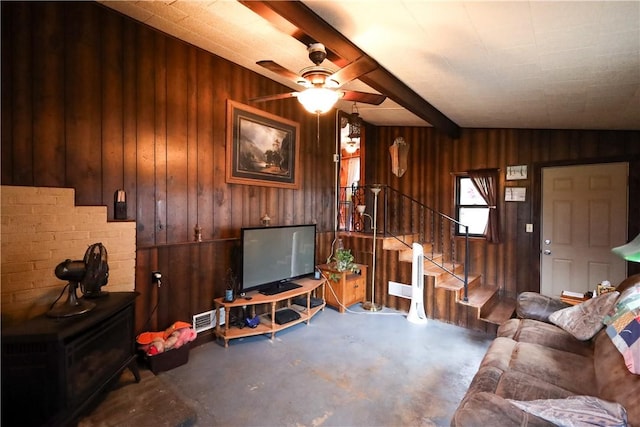 living room with wood walls, ceiling fan, and beam ceiling