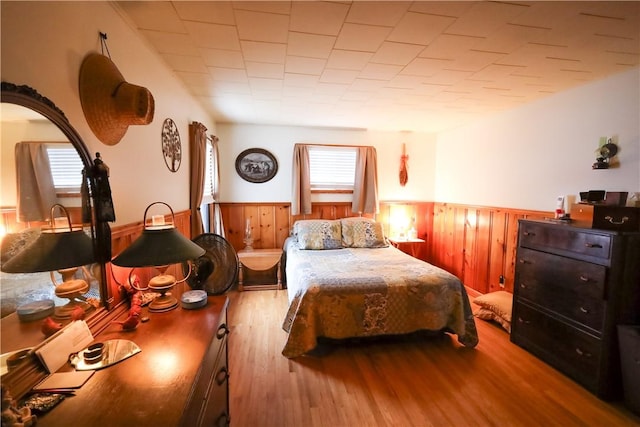 bedroom featuring wood walls and light hardwood / wood-style flooring